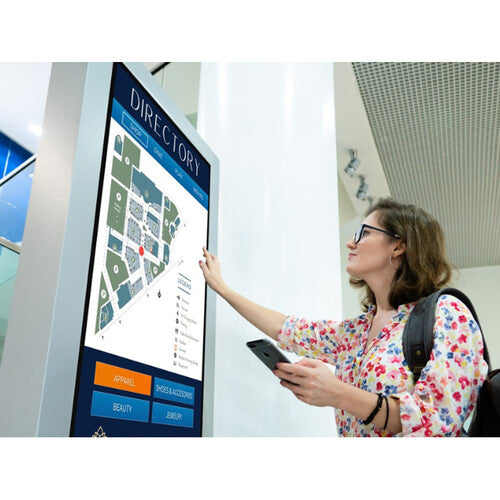 Planar Systems URP752 UltraRes P Series 75" UHD 4K HDR Commercial Monitor Woman interacting with a digital directory screen in an indoor setting